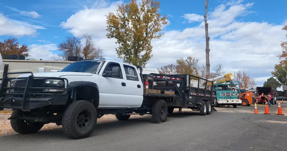 A white truck with a flatbed trailer 