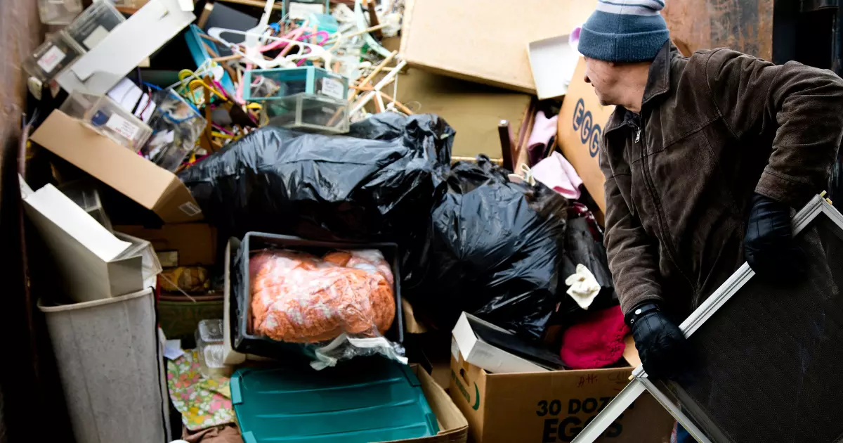 Worker organizing cluttered items during a commercial junk removal project